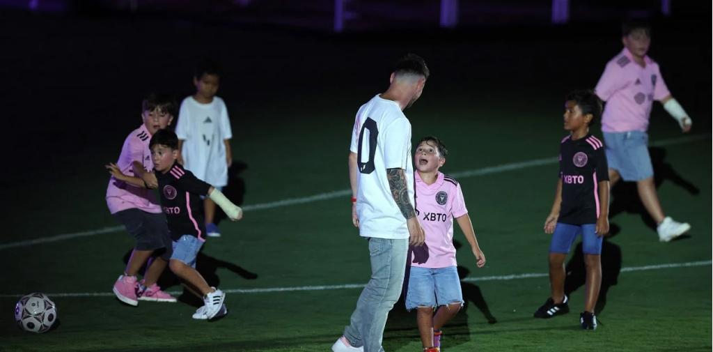 Lionel Messi habla con Mateo mientras Ciro, con el yeso, tira una gambeta. (Foto: AP)