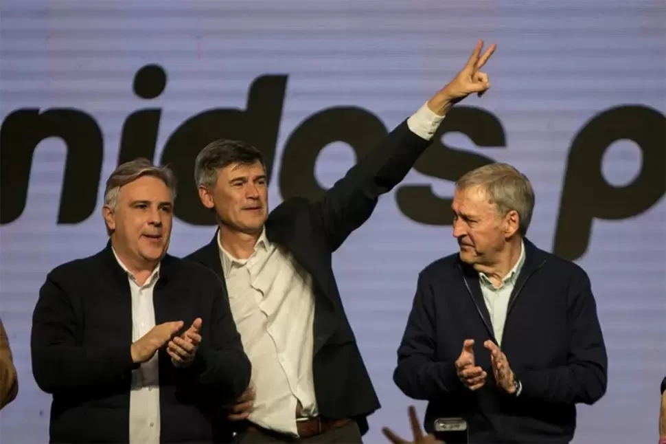 PERONISMO CORDOBÉS. Passerini celebra el triunfo de la mano de Llaryora (izquierda) y Schiaretti (derecha). foto de Sebastián Salguero