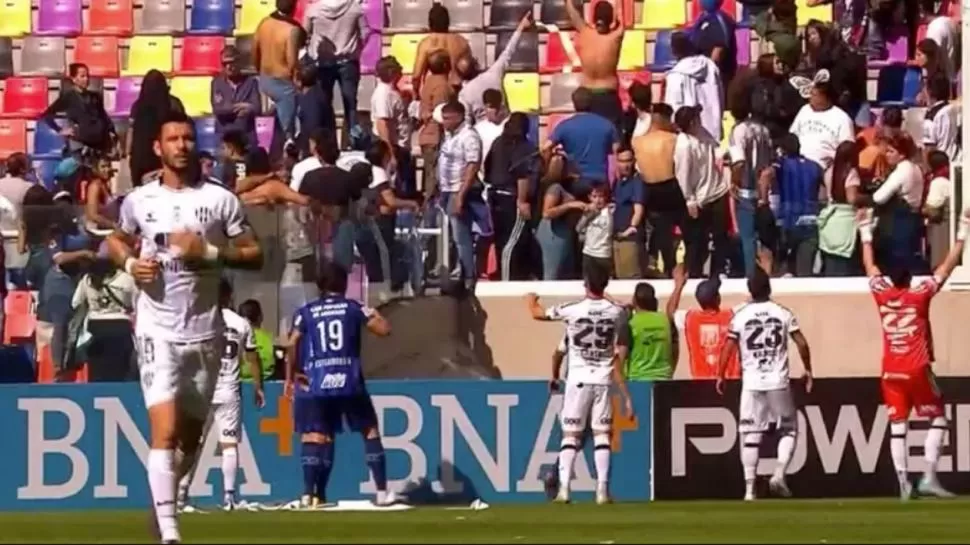 CAOS EN LAS TRIBUNAS. Los futbolistas pedían calma a un público enardecido. 