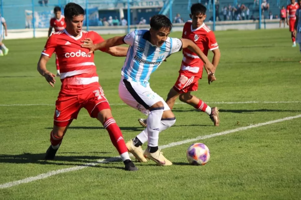 LUCHA. Granillo González cuida la pelota ante la marca de Daniel Zabala (2).  prensa atlètico tucumàn