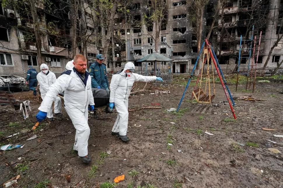 BÚSQUEDA. Expertos transportan el cuerpo de una persona muerta en uno de los bombardeos a Mariupol.  REUTERS