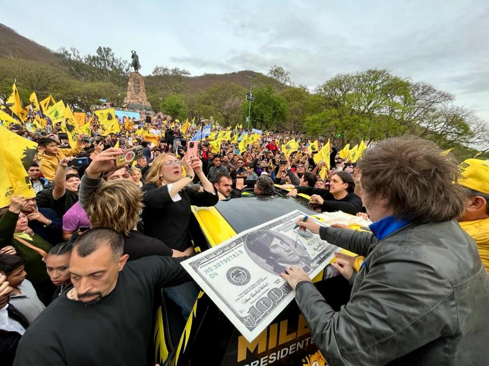 SELLO. El candidato libertario estampa su firma en la réplica de un dólar gigante que lleva impreso su rostro.