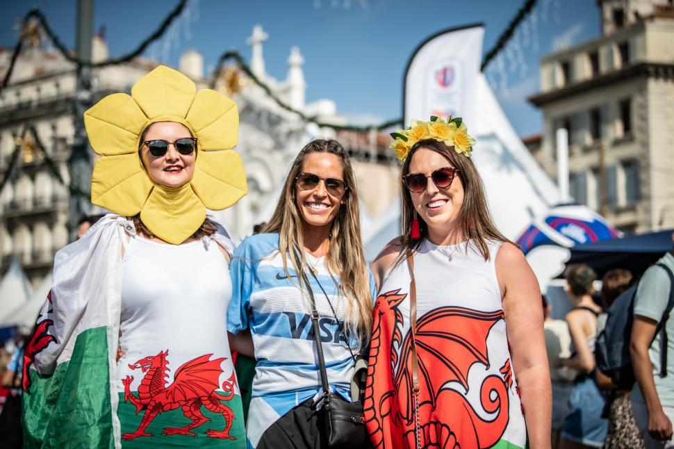 BUENA ONDA. La tucumana Carolina Vanni junto a dos hinchas de Gales.