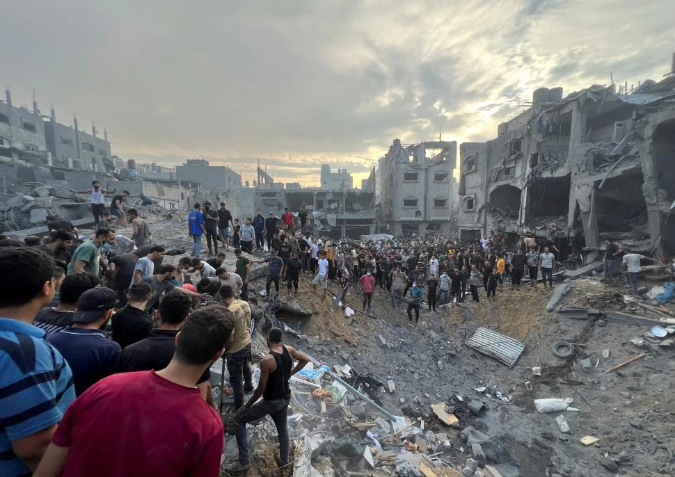 EN RUINAS. Palestinos caminan entre los restos del campo de Jabalia.