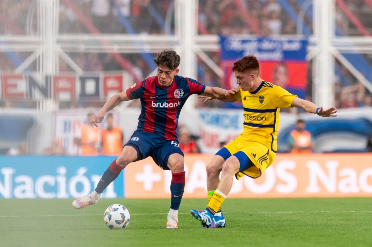 DUELO. Agustín Giay y Valentín Barco, compañeros en la Sub-20, disputan la pelota en el clásico. Foto: @sanlorenzo