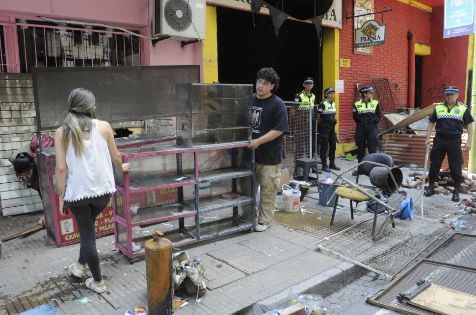 EXCEPCIÓN. La Policía sólo permitió a los puesteros llevarse las estanterías que estaban tiradas en la vereda; no se autorizó el ingreso al mercado. la gaceta / fotos de antonio ferroni