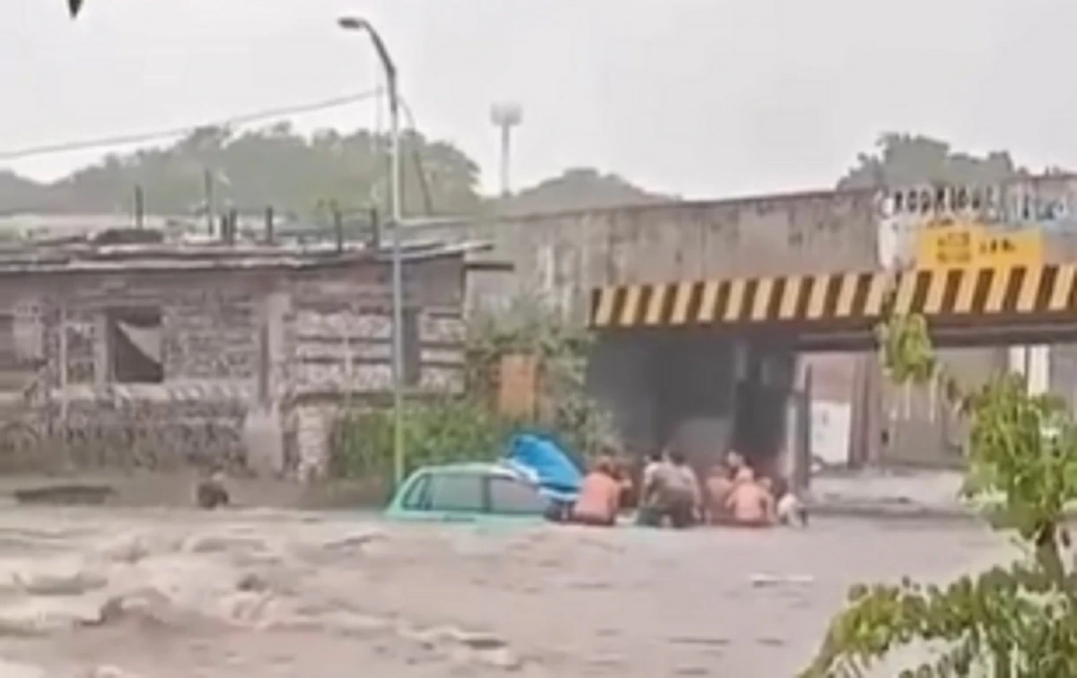 COMPLICACIONES. Vecinos tratan de sacar del agua a un auto en México y San Miguel. 