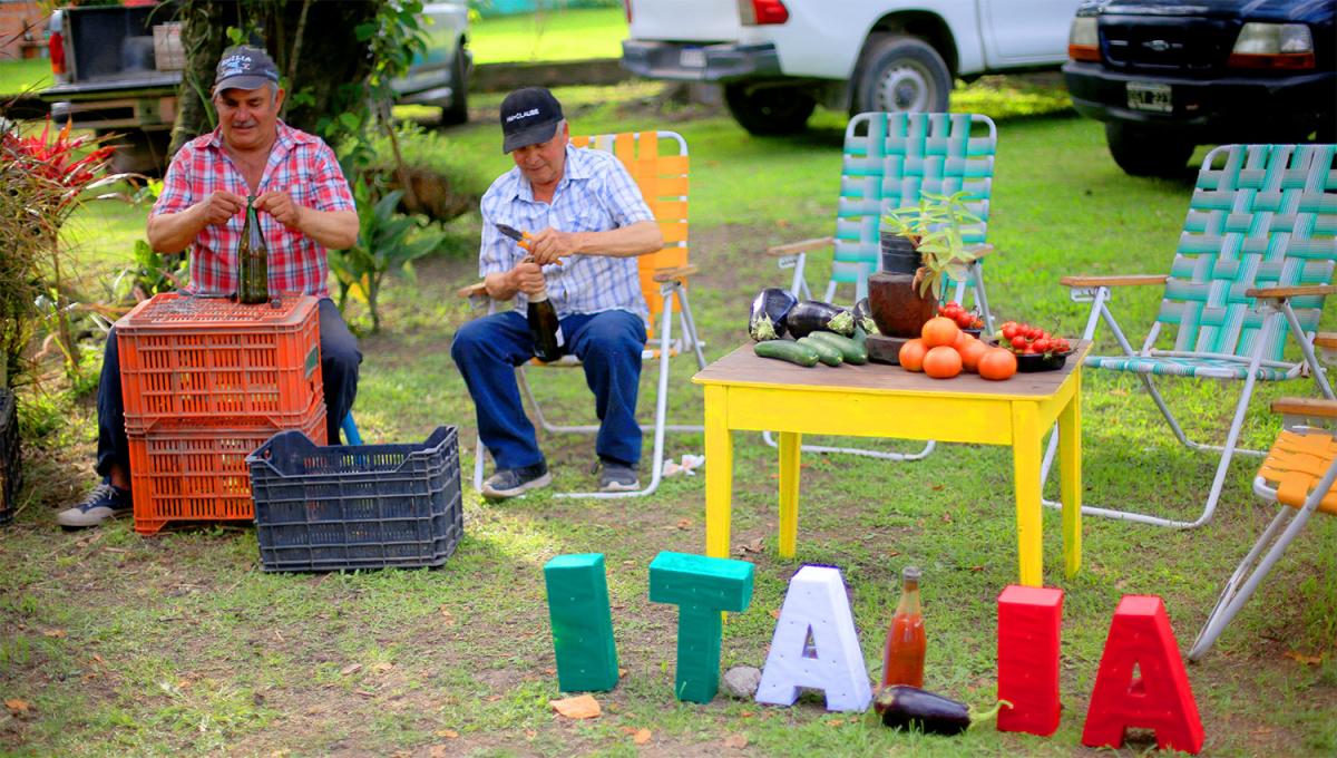 Los hombres ajustan con alambre el corcho de una botella para que no se abra durante la cocción