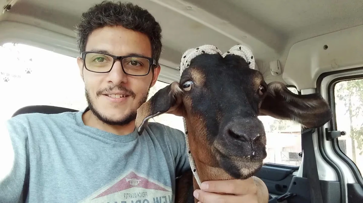 EL JOVEN, feliz, junto a la cabra salvada. 