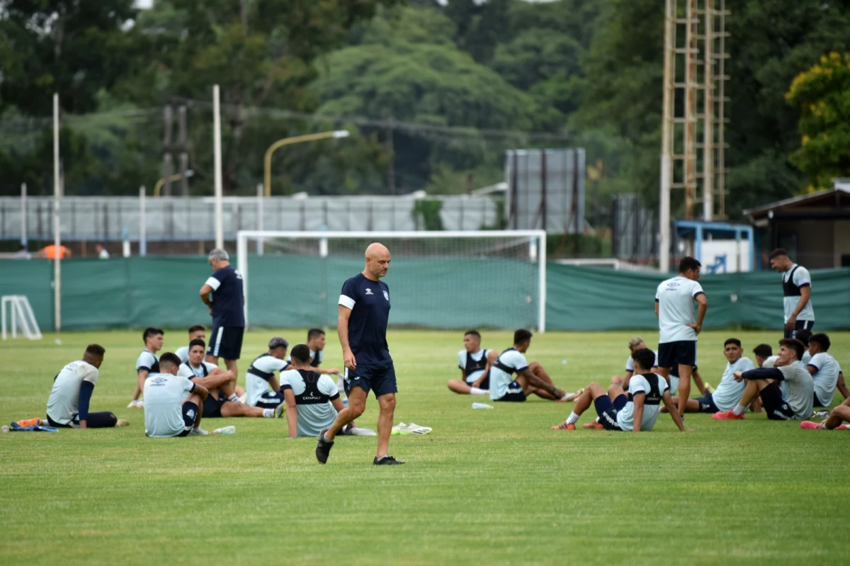 PENSATIVO. Orsi deja la cancha tras una práctica, con sus jugadores elongando de fondo