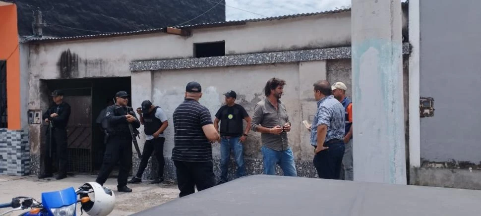 ESPERA. Los efectivos en la puerta de una de las viviendas donde secuestraron mercadería de Desarrollo Social.