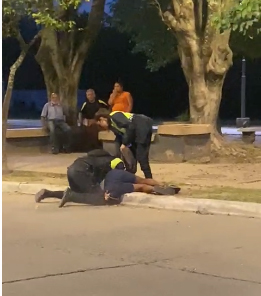 ESFUERZO. Dos policías reducen al acusado ante la mirada de vecinos.