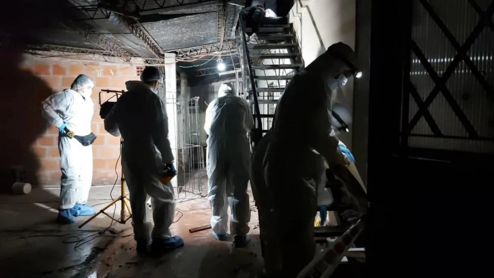 EN LA ESCENA DEL CRIMEN. Los peritos del ECIF buscan pruebas en el interior de la vivienda donde cayó sin vida el joven de 21 años.