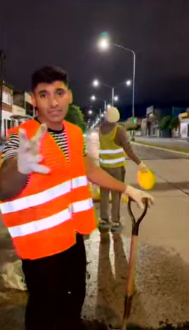 LA TAREA. Los jóvenes, con chalecos reflectantes, arreglan el bache.