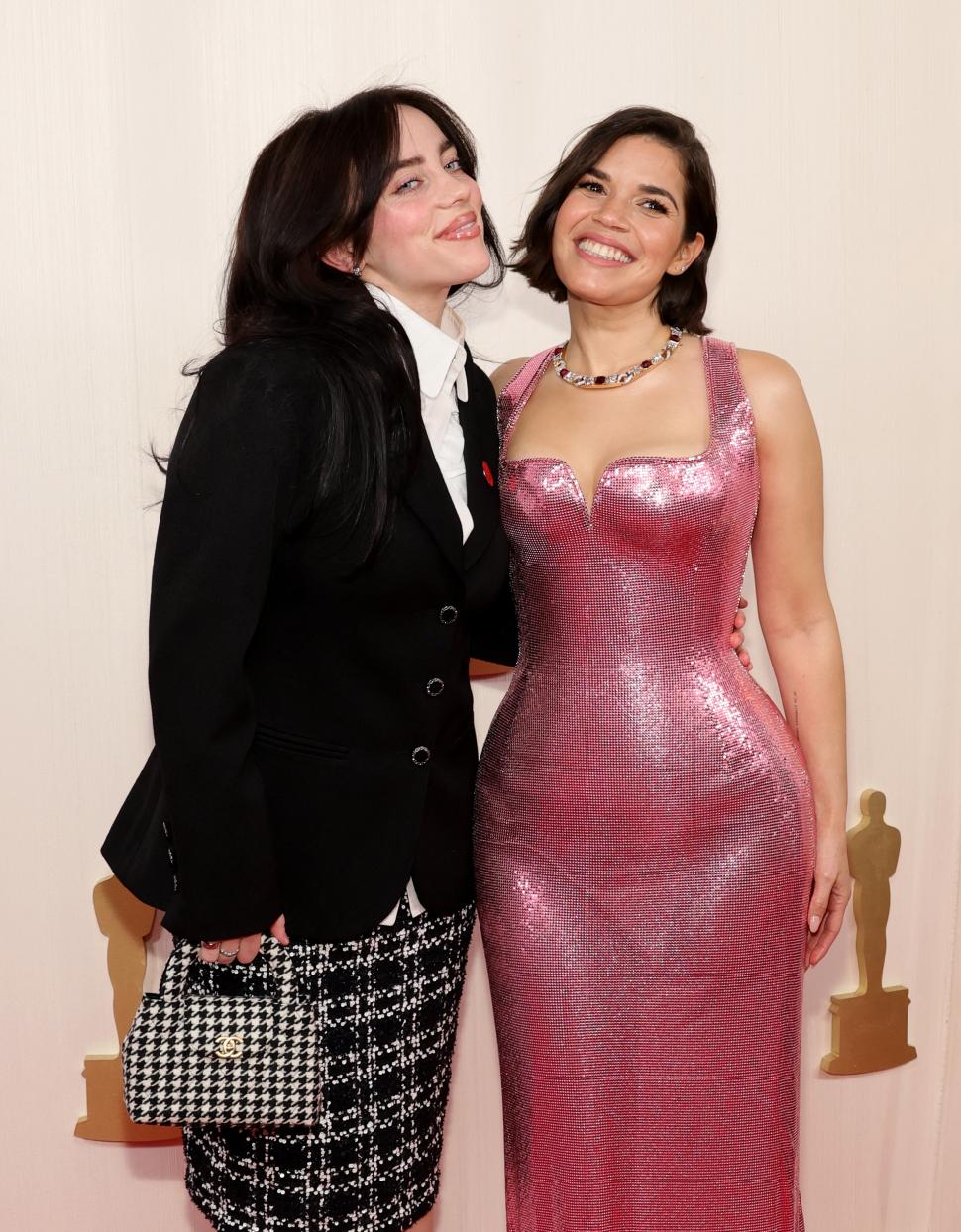 AMIGAS. La cantante Billie Eilish y la actriz America Ferrera (“Barbie”). Esta última eligió un vestido en tono rosa fucsia con textura brillante y original escote.