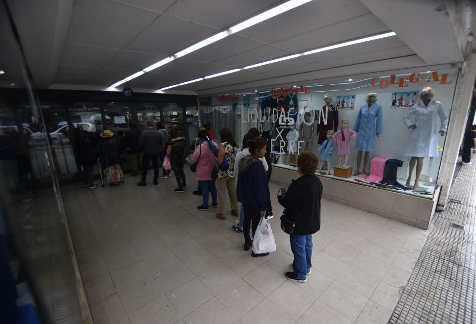 EN LA CALLE. Clientes hacen largas colas para realizar su última compra.