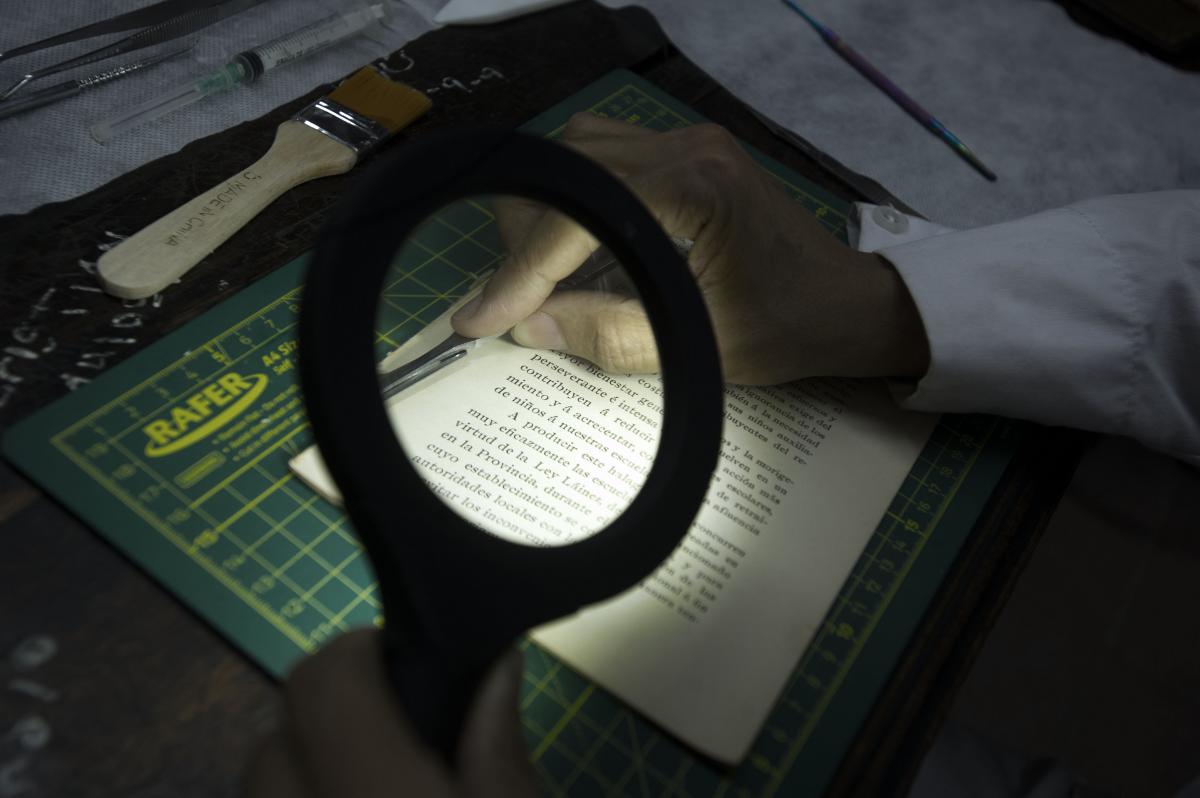 BUSCANDO DETALLES. La intervención requiere revisar centímetro a centímetro cada página, en procura de analizar el estado del libro.