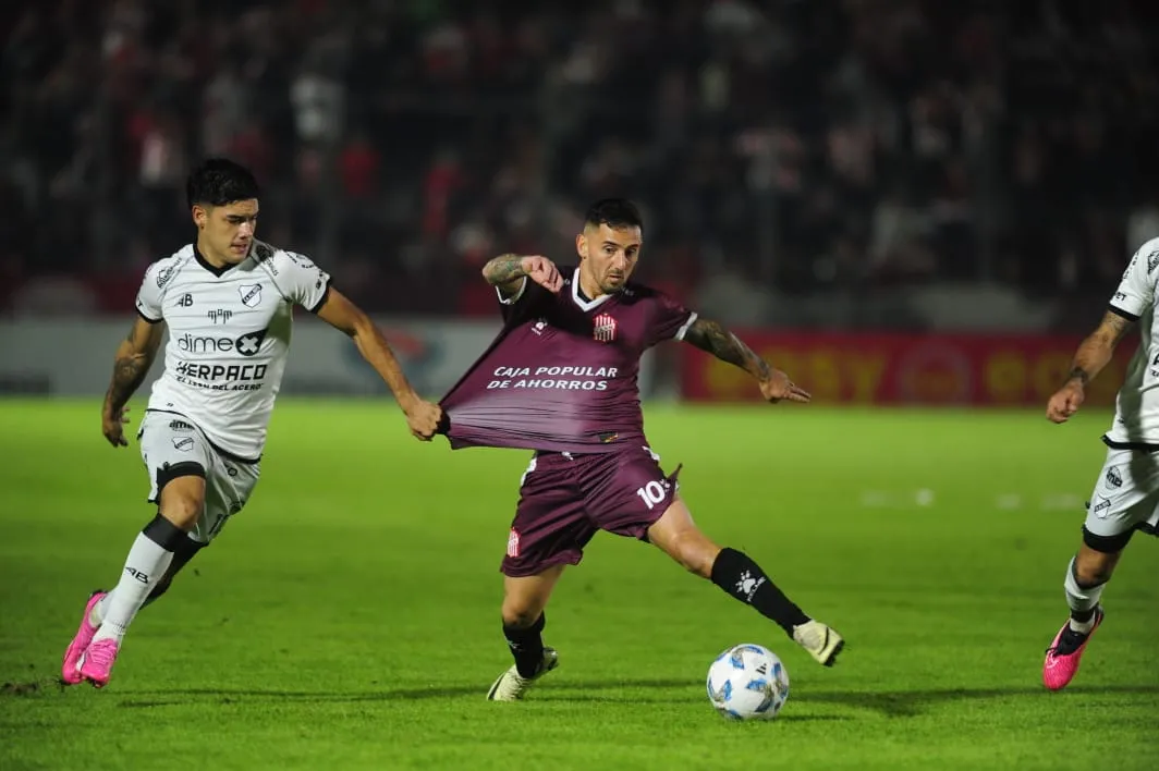 DE CERCA. Juan Cuevas intenta zafarse de la marca de Santiago Patroni.