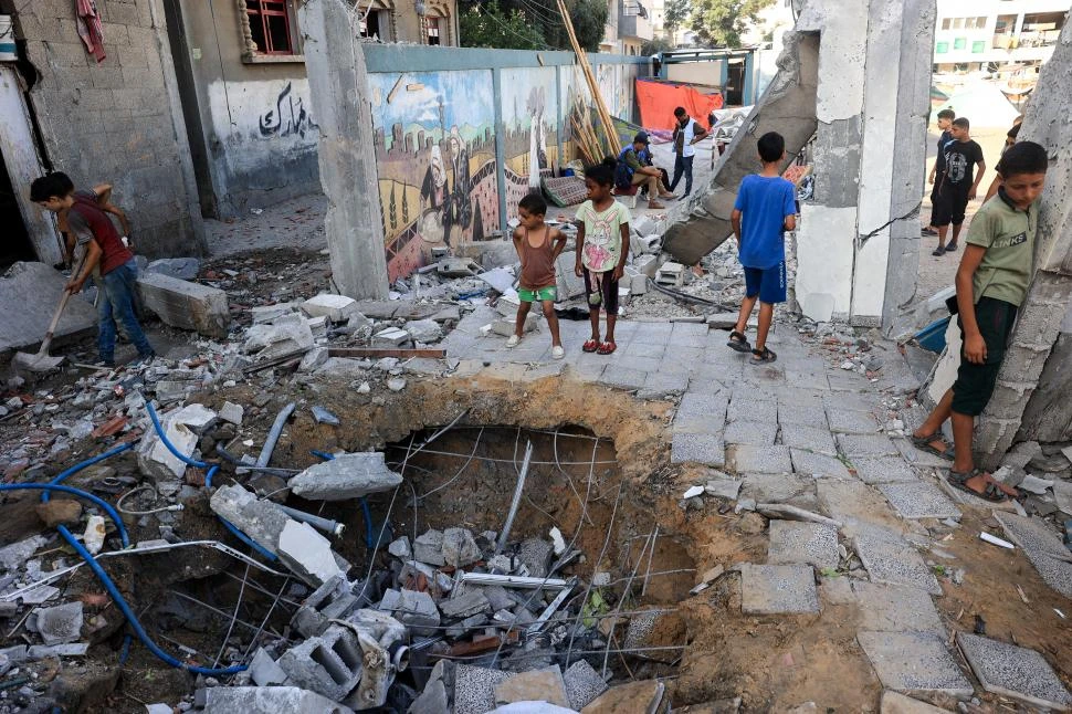 SIN CONSUELO. Un grupo de niños recorre las ruinas de la escuela de Nuseirat, en el centro de Franja de Gaza.  