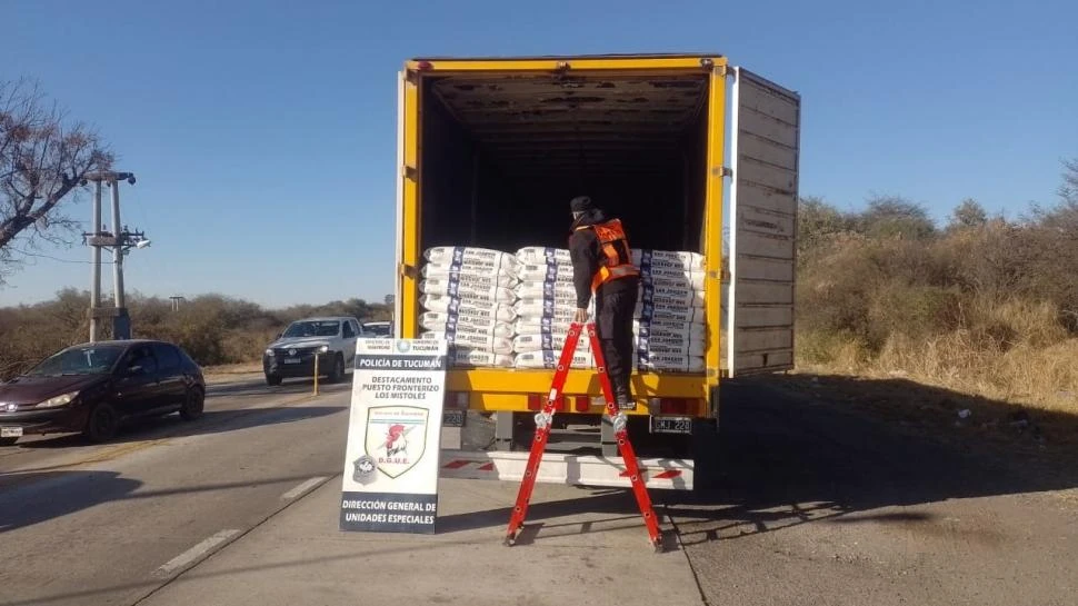 PLENO PROCESO. Un efectivo se sube a una escalera para contar las bolsas de azúcar que eran transportadas sin la respectiva documentación.