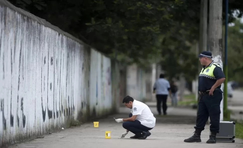 CRIMINALÍSTICA. Peritos de la Policía estudian la escena del crimen de Luciano Gastón Calderón, en Blas Parera al 500, donde recogieron vainas. 