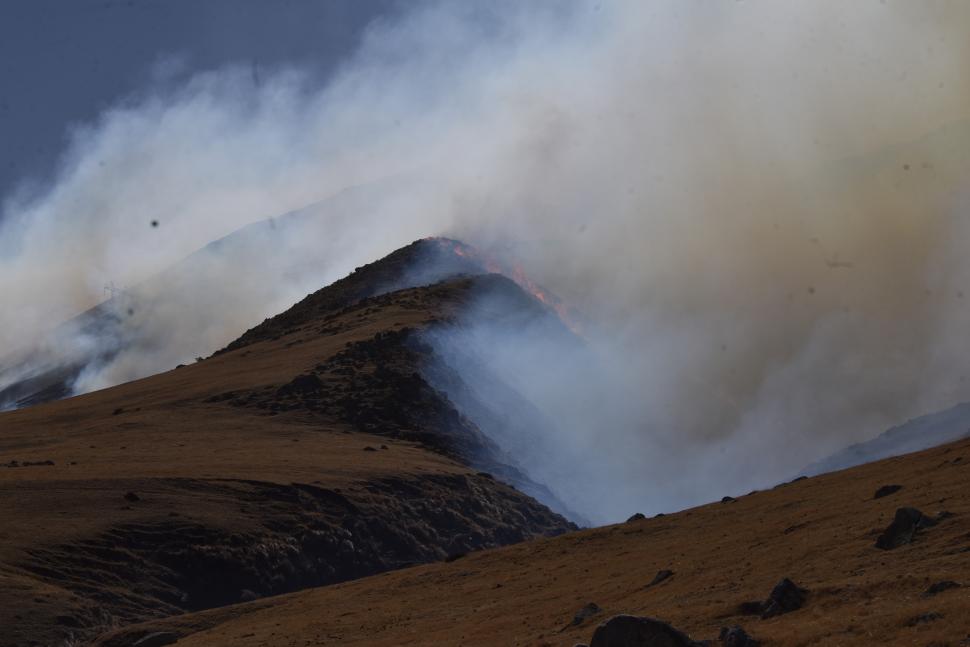 LAS DOS CARAS. Una ladera del cerro intacta mientras la otra se incendia.