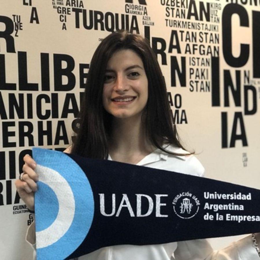 BECARIA ARGENTINA. Luciana Paione Oleszuk posando junto a la bandera de su universidad./UADE