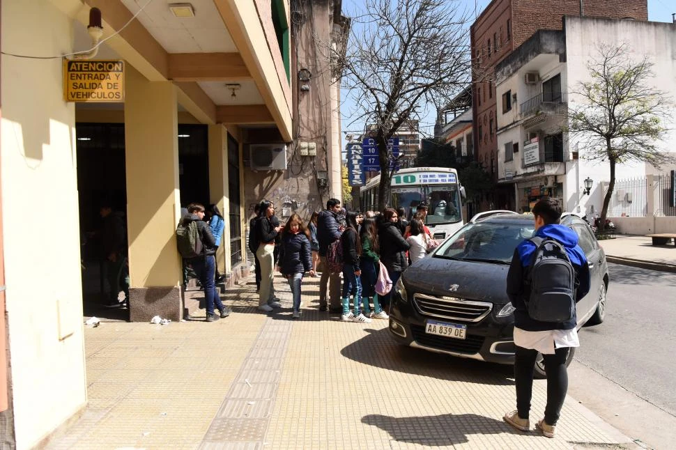 DE PERFIL. Un auto se abre paso entre los usuarios del transporte para entrar al edificio de la San Lorenzo.