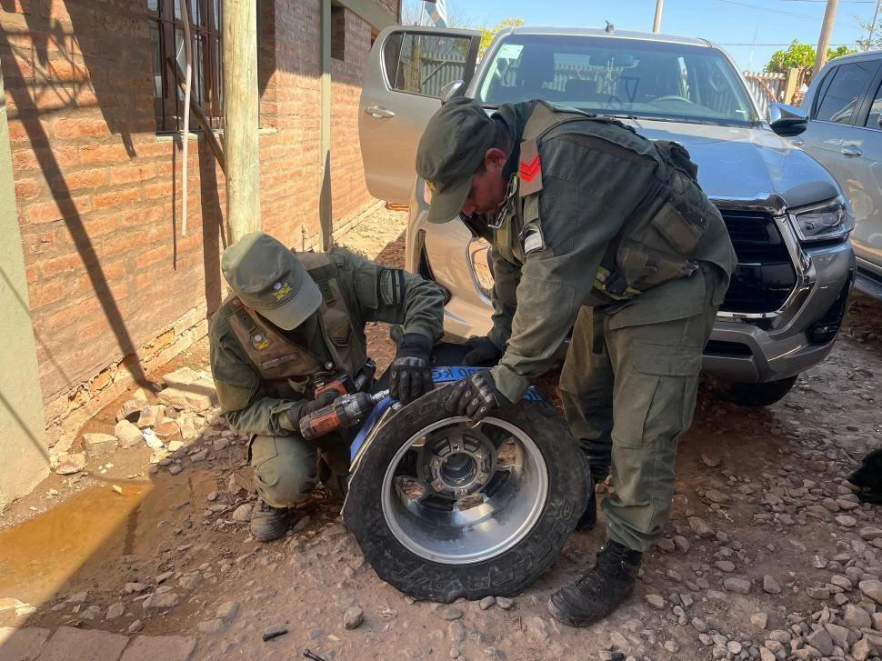 EN PLENA TAREA. Dos gendarmes trabajan desarmando una rueda donde estaba parte de los 110 kilos de cocaína que fue secuestrado.