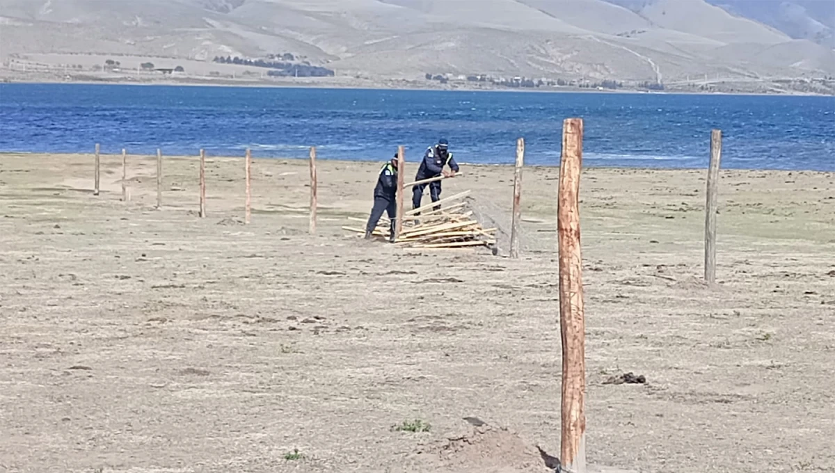 EN EL DIQUE. Miembros de la Policía se encargaron del desmantelamiento del cercado puesto en Tafí del Valle.