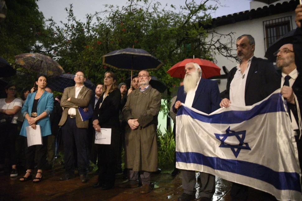 REPUDIO Y PEDIDO. Bajo la lluvia, miembros de la comunidad judía se congregaron en el patio de la Casa Histórica para reclamar por la paz en Israel. 