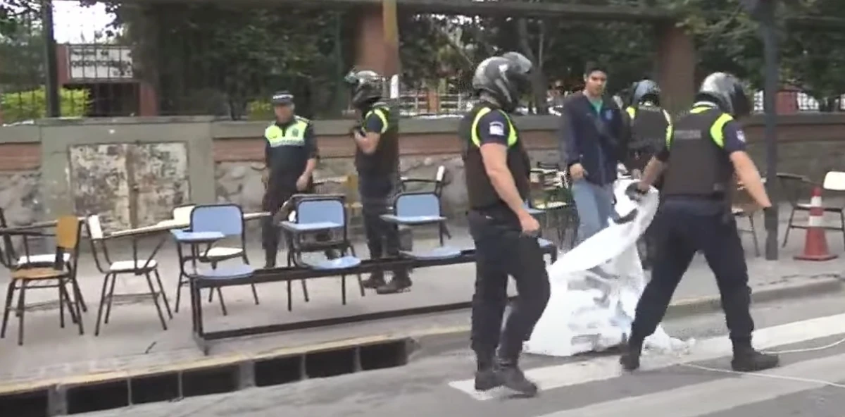 Policías mueven sillas, bancos y carteles. CAPTURA DE VIDEO