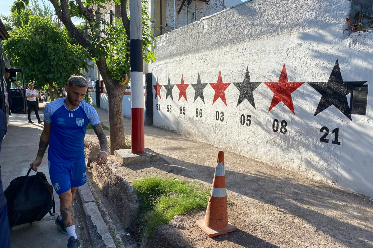 COLABORA SIEMPRE. Tesuri lleva un bolso de utilería desde el micro hasta el campo de juego de Maipú. El volante volvió a Mendoza, una ciudad especial para él.