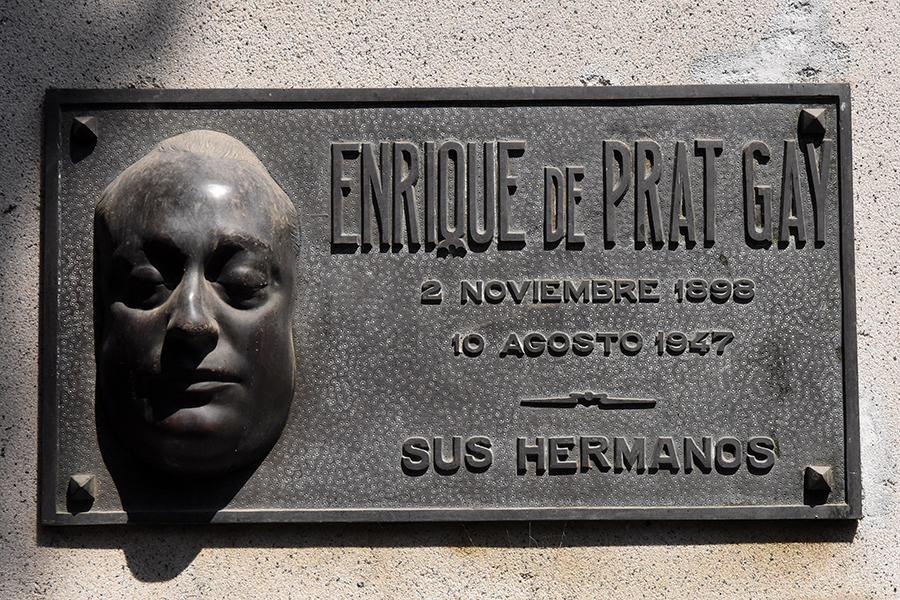 ENRIQUE DE PRAT GAY. El rostro del escultor asoma en la placa con la forma de una máscara mortuoria. Una de las más impresionantes.