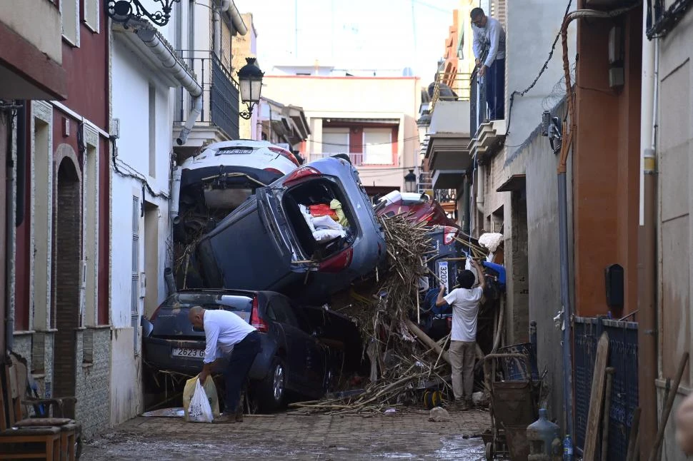 COMO EN UNA PESADILLA. La fuerza del agua arrastró autos y los dejó apilados en las calles de Paiporta; muchos de ellos, con personas adentro.  