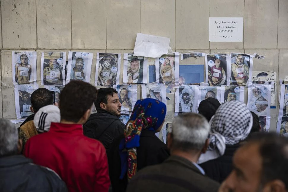 BÚSQUEDA. Miles de sirios se apiñan frente al hospital de Damasco, para ver si entre las fotos de cadáveres encuentran a sus familiares desaparecidos. fotos afp