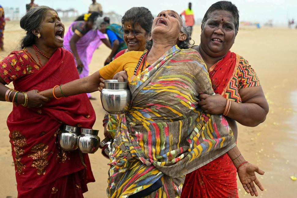 INDIA. Una mujer llora durante un rito religioso.