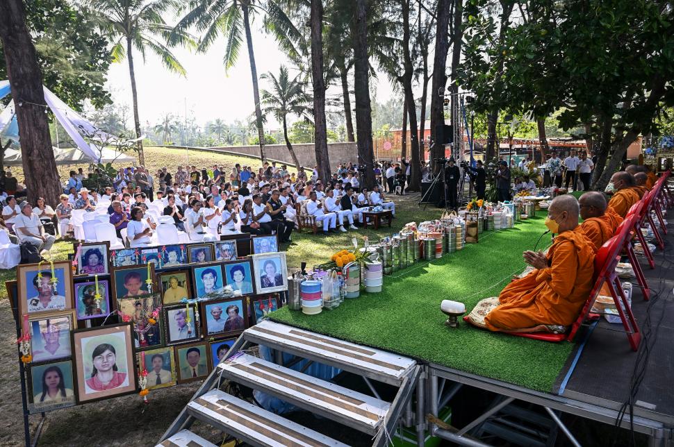 CONFLUENCIA RELIGIOSA. Monjes y fieles de distintas creencias durante el homenaje junto a retratos de víctimas en el sitio de memoria en Thailandia.