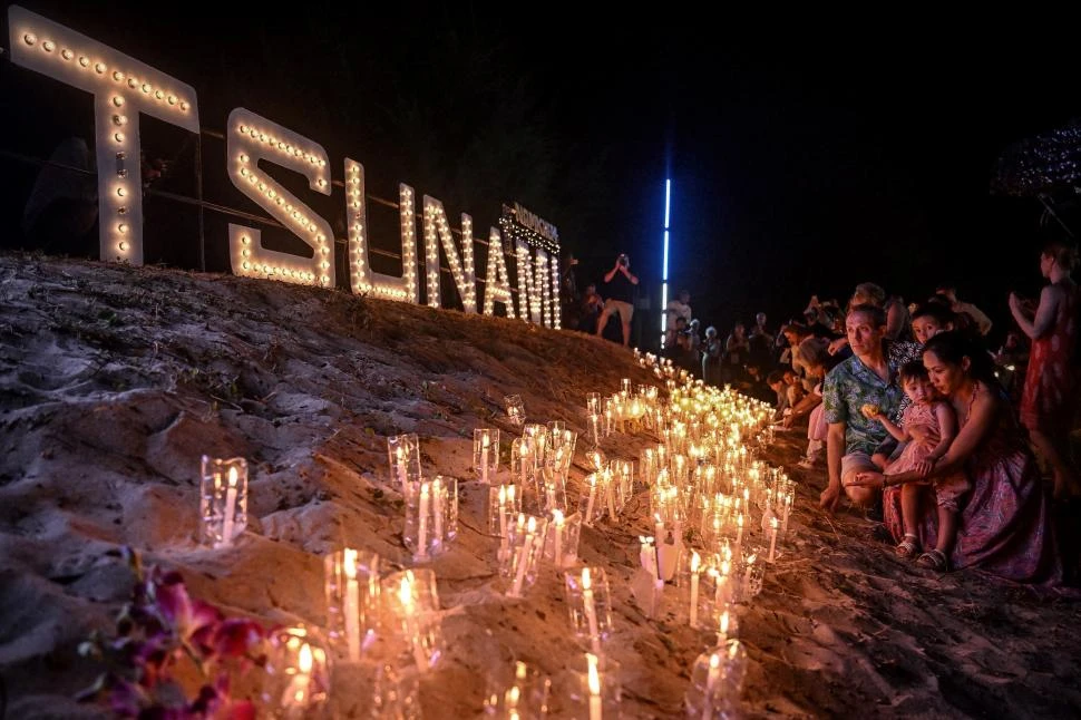 VELAS EN LA PLAYA. La gente afligida al comienzo del homenaje en el sitio de memoria en la provincia de Phang Nga, al sur de Tailandia. fotos afp