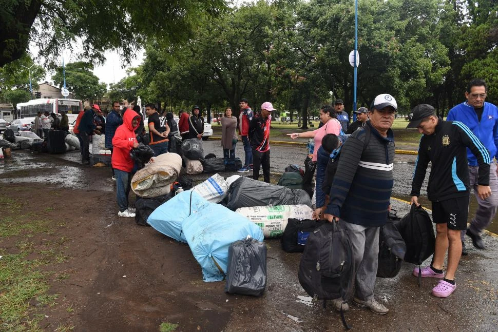 BAJO EL AGUA. Familiares de los obreros que partieron ayer al sur desde el parque 9 de Julio ayudaron a cargar los bolsos en medio de la tormenta. la gaceta / fotos de josé nuno