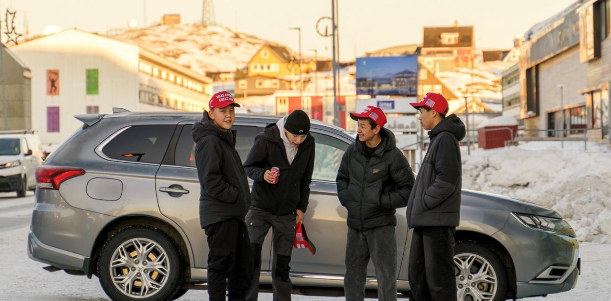 Habitantes de Groenlandia, con los gorros rojos de la campaña de Donald Trump