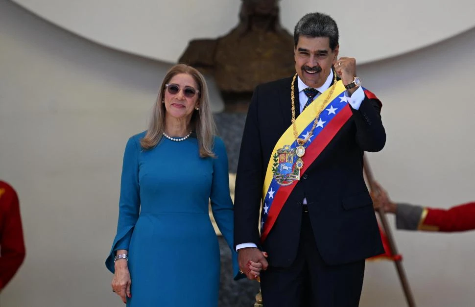 FELIZ. Maduro, tras el juramento, camina con su esposa Cilia Flores. El mandatario prometió tiempos de paz. afp