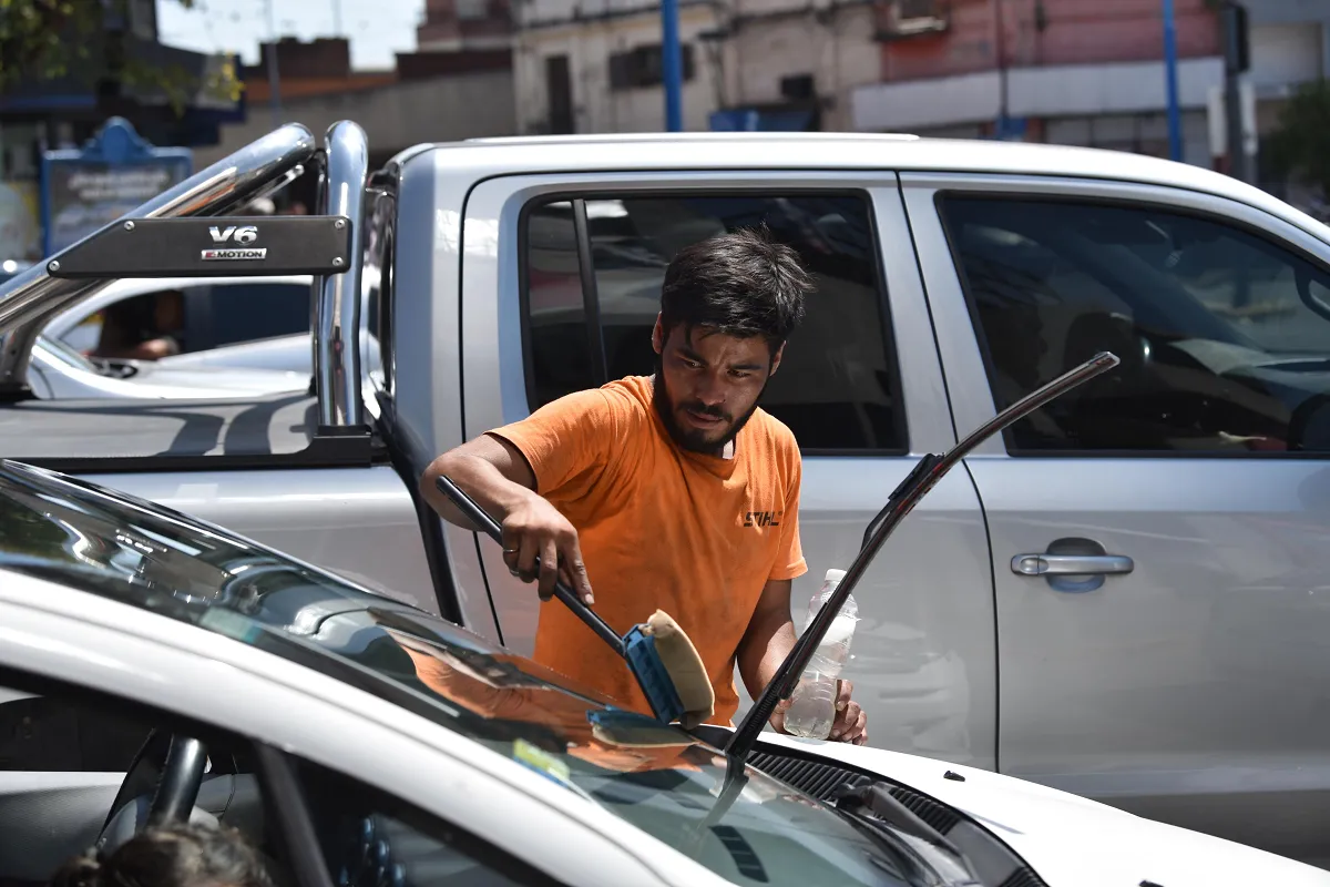 UNA CONSTANTE. Decenas de tucumanos se apuestan durante el día en las principales esquinas de la capital para vender productos y limpiar vidrios.