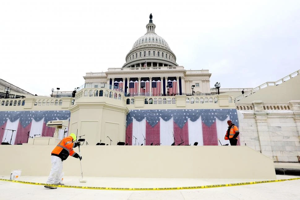 FRENTE OESTE. Cuadrillas de obreros y técnicos trabajan para dejar listo el ingreso al Capitolio para la inauguración del segundo mandato de Trump.  afp