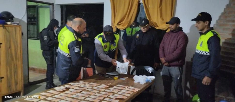 CONTROLANDO LA EVIDENCIA. Los policías analizan las sustancias en una mesa donde se colocó todo el dinero secuestrado a los jóvenes.