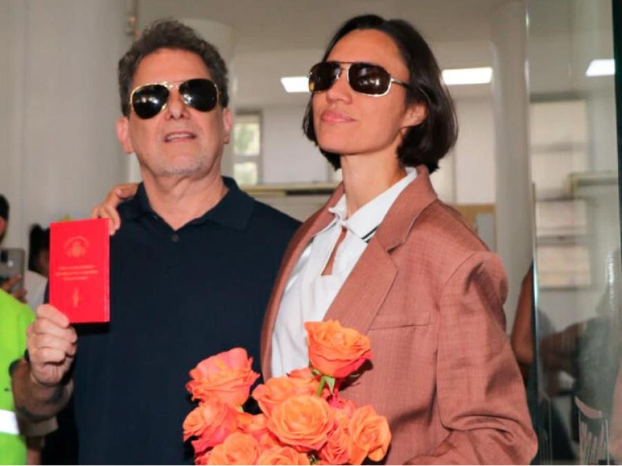 A la salida del registro civil, los recién casados posaron con su libreta de familia .