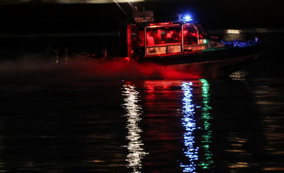 Equipos de policía, bomberos y servicios de emergencia llevan a cabo una operación de búsqueda y rescate en la zona del impacto de un accidente aéreo cerca del aeropuerto Reagan.