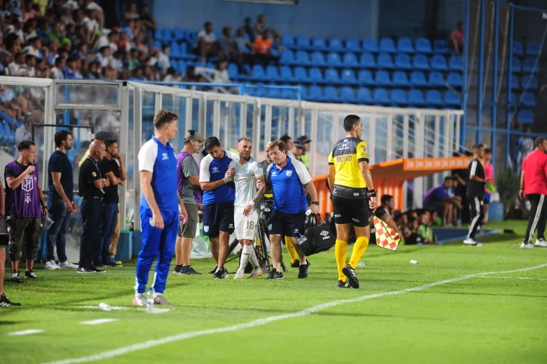 LLORANDO. Tesuri sale de la cancha ayudado por los médicos. Luego volvió a ver el partido desde el banco de suplentes. FOTO DE DIEGO ARÁOZ