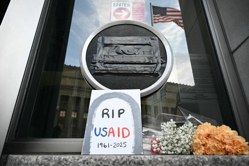 CERRADO. En la sede de Usaid en Washington, donde hasta el logo está tapado, pusieron ofrendas mortuorias. AFP