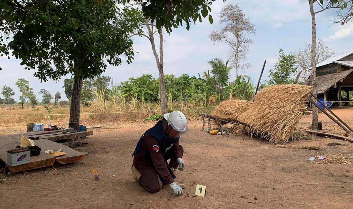 Un desminador del Centro de Acción contra Minas de Camboya inspecciona fragmentos de una granada propulsada por cohete de hace décadas. Fotografía: AP/The Guardian